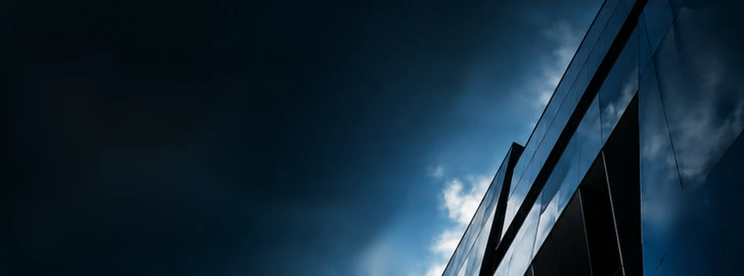 Modern glass building reflecting a twilight sky